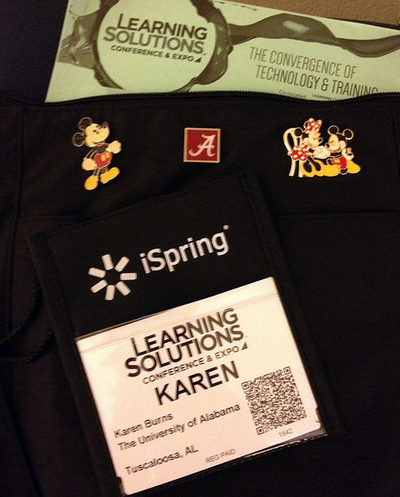 Close-up of disney pins, UA pin, and conference badge.
